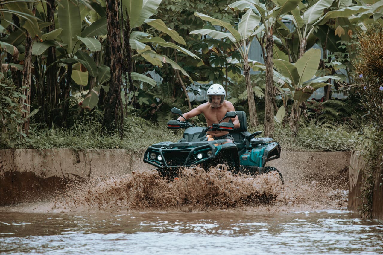 Rider navigating a muddy jungle trail during a Bali tour ATV experience with Mr Bali Tour