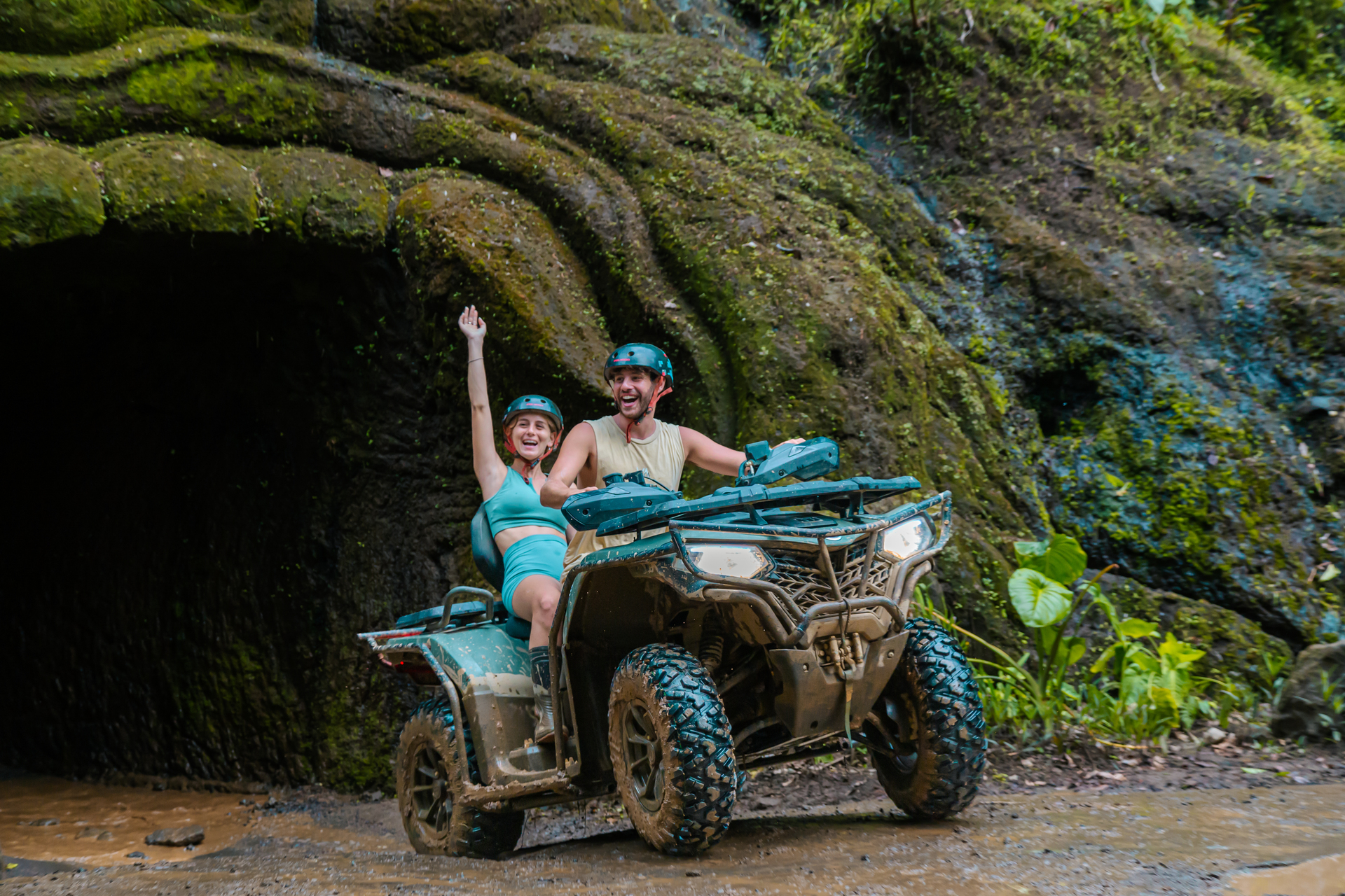 Riders tackling a muddy riverbed on a Bali tour quad bike adventure with Mr Bali Tour