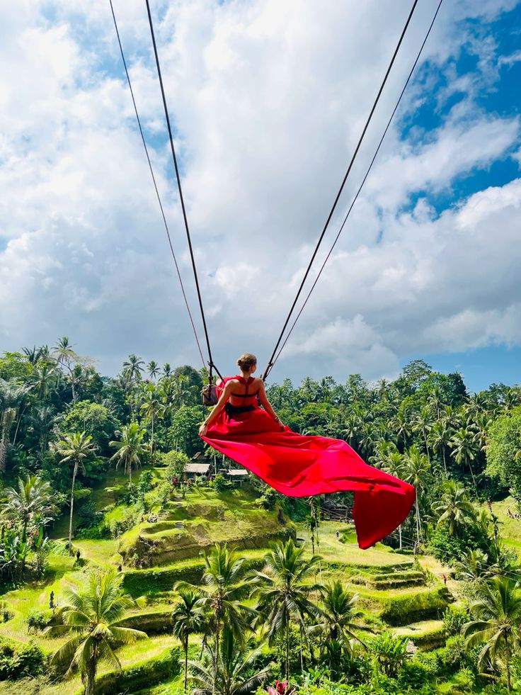 Traveler soaring over a green jungle valley during a Bali tour swing adventure with Mr Bali Tour